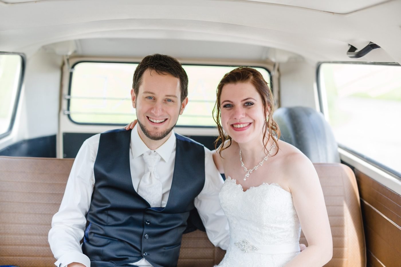 VW Büssli mit Brautpaar vor der Kirche – © Miandla Photography